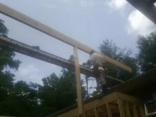 Carpenter setting a ridge beam over a new addition frame — Ice Dam Removal by Roofing Brothers in Green Camp
