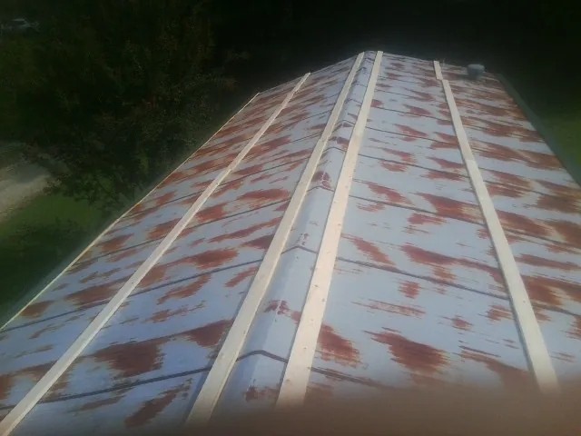 Rusted metal roof panels with new wood purlins before replacement — Storm Damage Roof Repair in Green Camp by Roofing Brothers