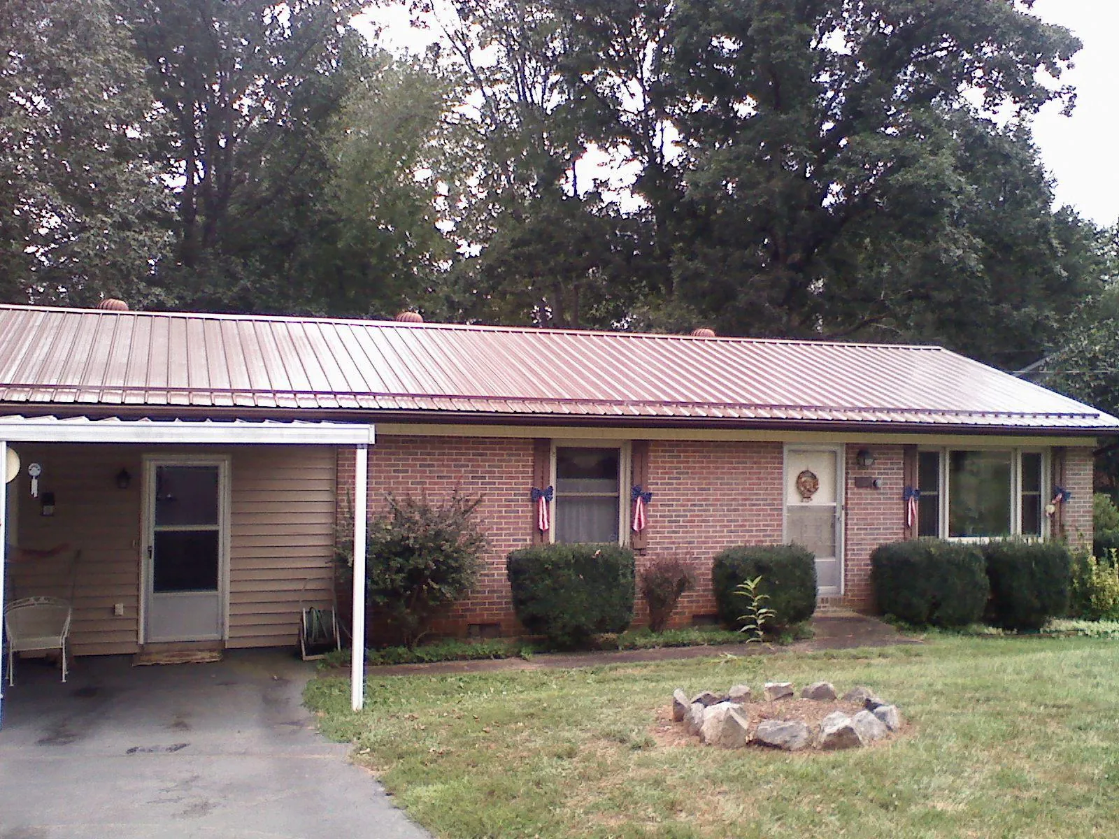 Bronze metal roof and carport on a brick ranch home — Roof Repair work by our crew in Green Camp